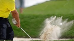 pro-golfer-hitting-sand-bunker-shot-wearing-yellow-shirt_79390-2009